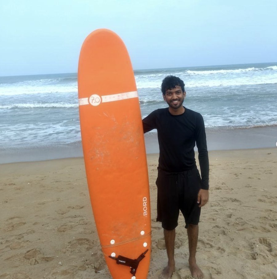 Savan with a surfboard on Mahabalipuram beach